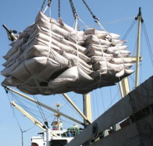 Carregamento de açúcar ensacado em navio para exportação.